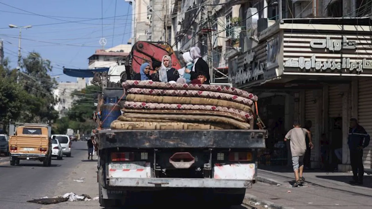 Tens of thousands flee south in bombarded Gaza as Israeli troops gather near border