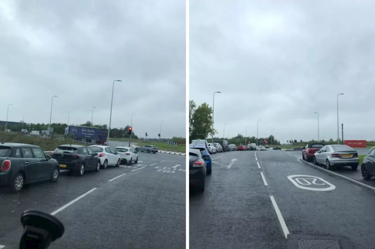 Dozens of cars park near busy roundabout at M8