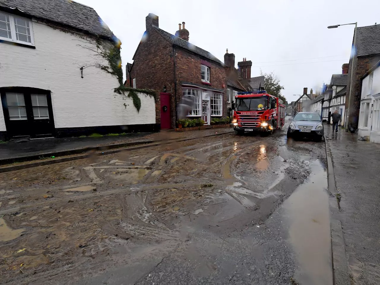 Townsfolk muck in to clear Much Wenlock's flooded roads with thick mud left behind