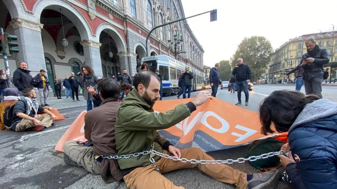 Gli attivisti di Ultima Generazione incatenati per strada davanti a Porta Nuova