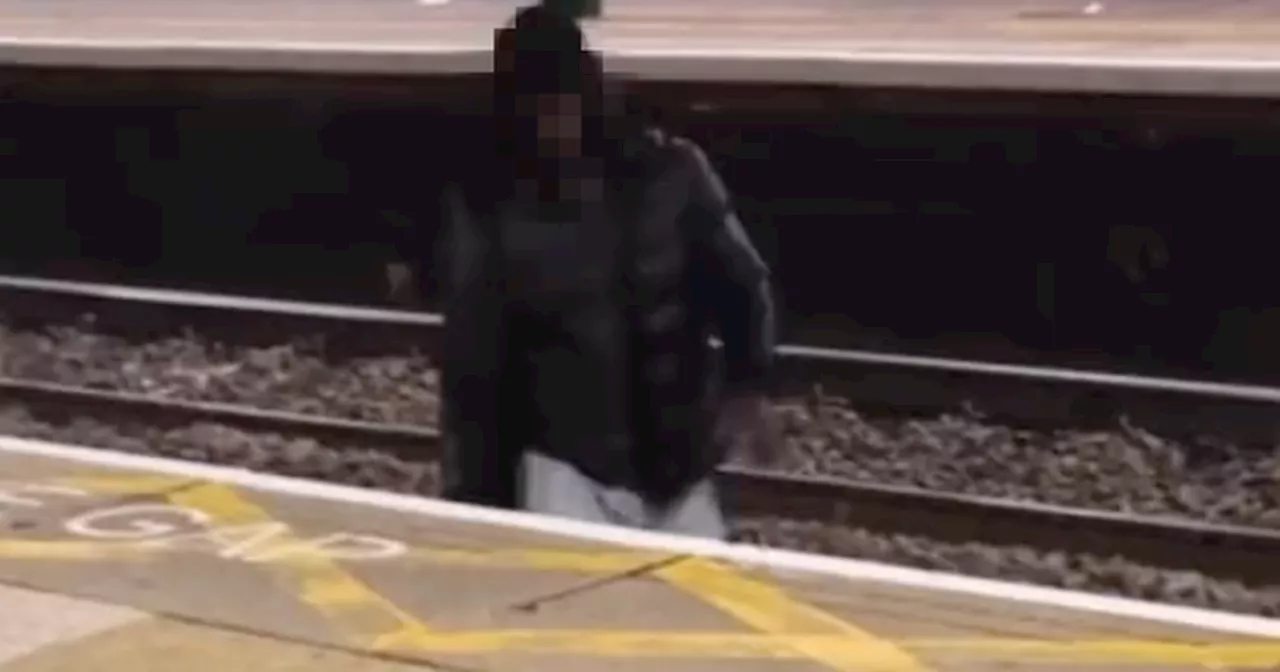 Man filmed climbing over live train tracks to harass lone woman at station