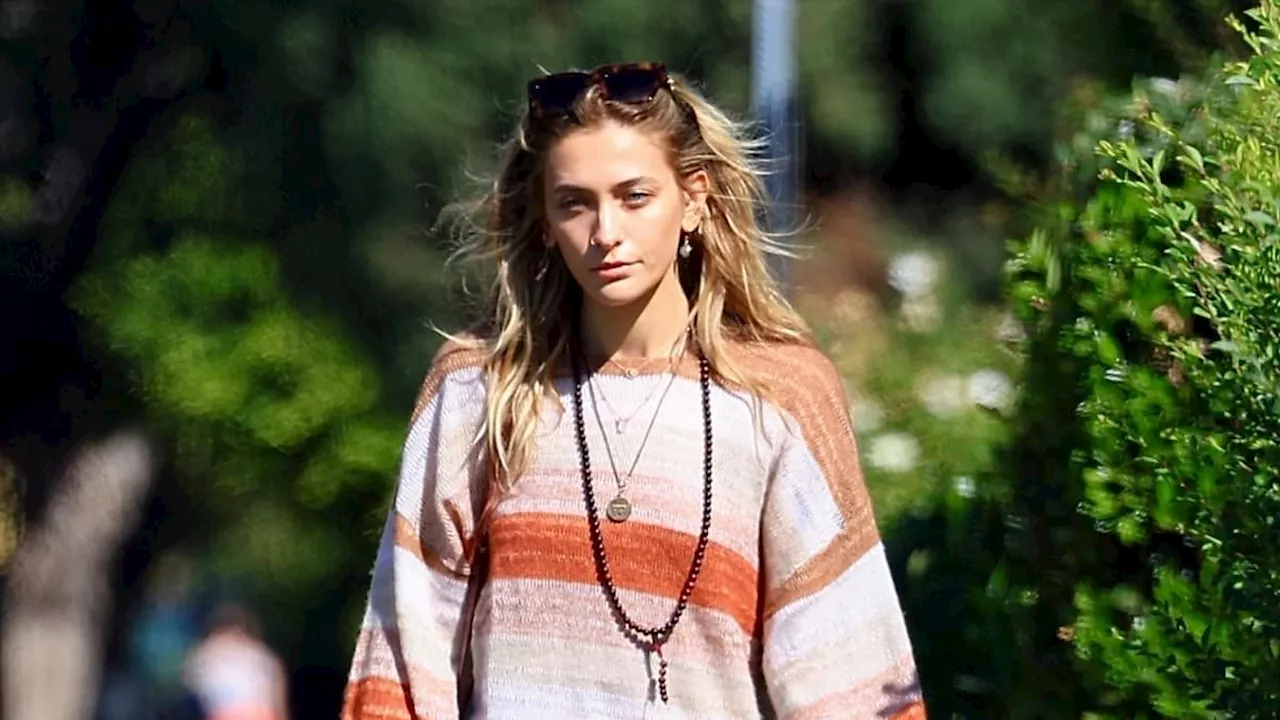 Paris Jackson wears an autumn-inspired striped sweater and very ripped jeans during a stroll with...