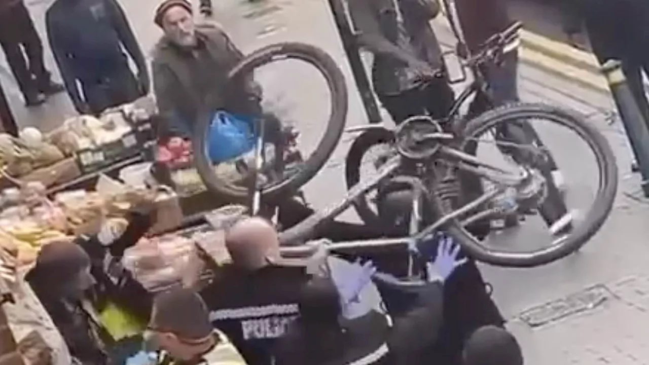 Shocking moment thug batters three police officers over the head with a BIKE during street...