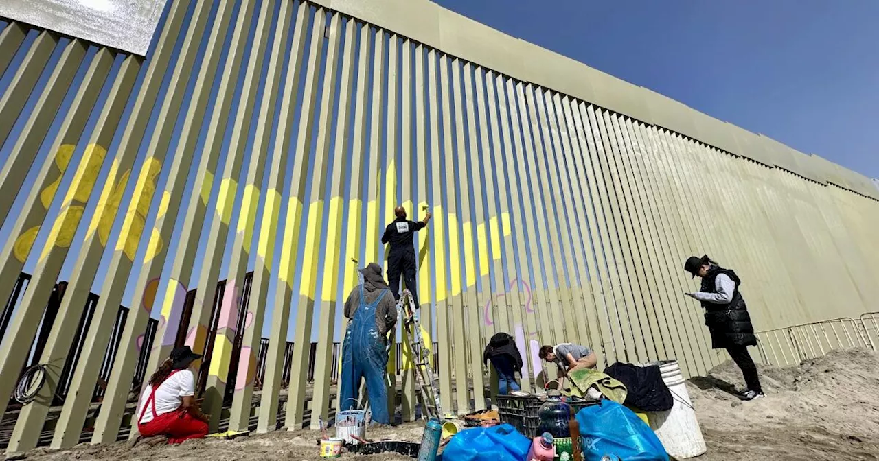 Artistas pintan el recién remplazado muro fronterizo en Tijuana