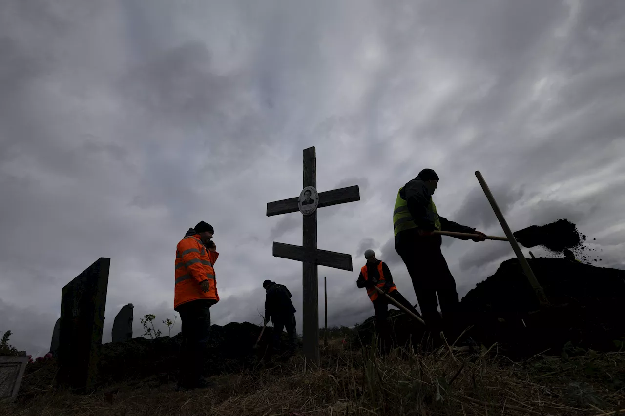 Ukrainian villagers weep as they bury victims of Hroza missile strike