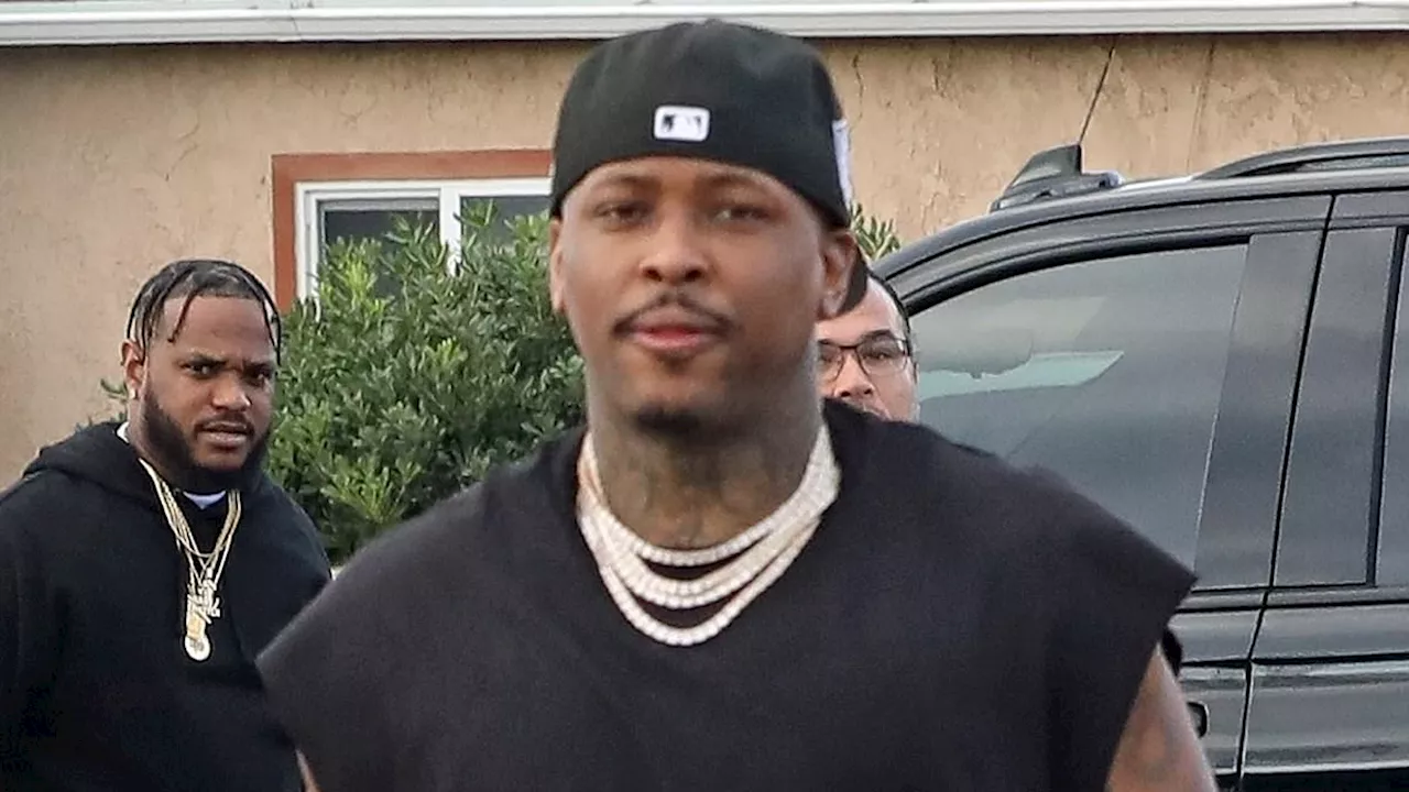 Rapper YG volunteers at Thanksgiving food drive with security guards carrying assault rifles