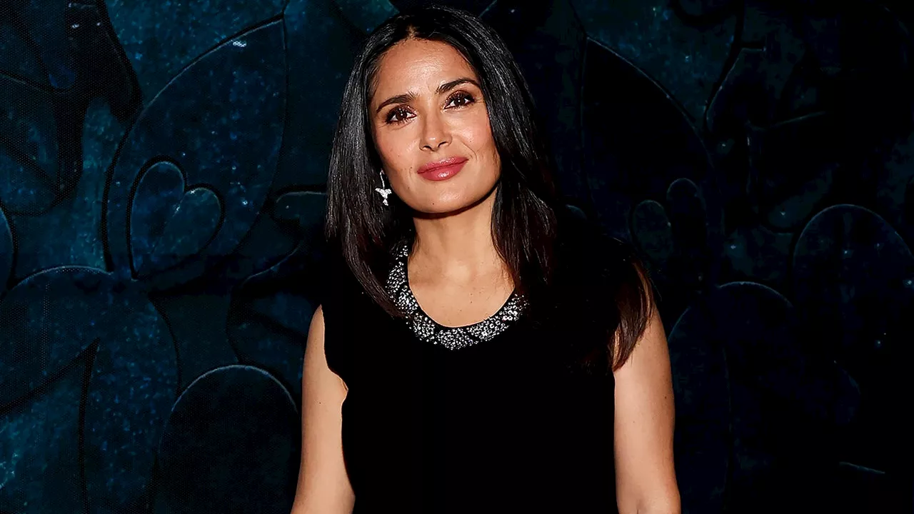 Salma Hayek con una falda y sandalias de plataforma plateadas que desafían el uniforme de oficina