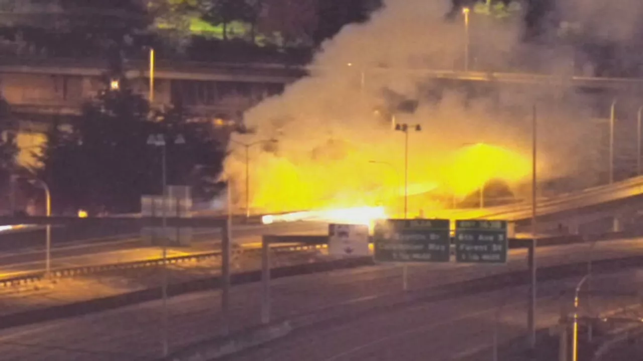 2-story structure catches fire at Seattle homeless encampment, sending flames across I-5