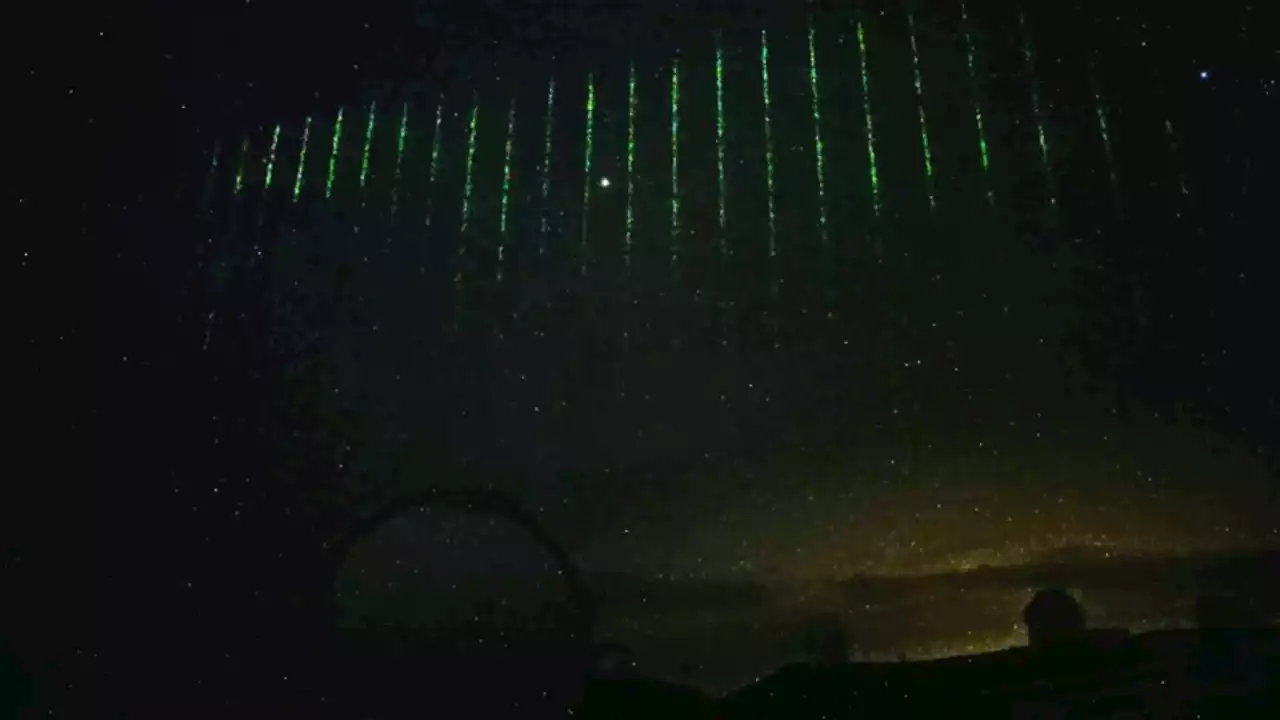 Photos show bright green lasers shooting across the night sky above Hawaii