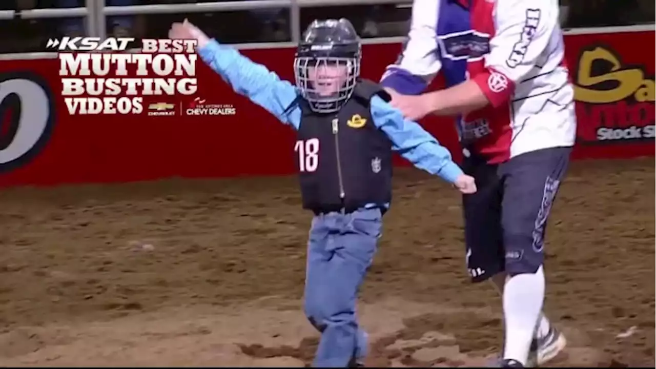 Proud child waves after Mutton Busting ride at San Antonio Stock Show & Rodeo