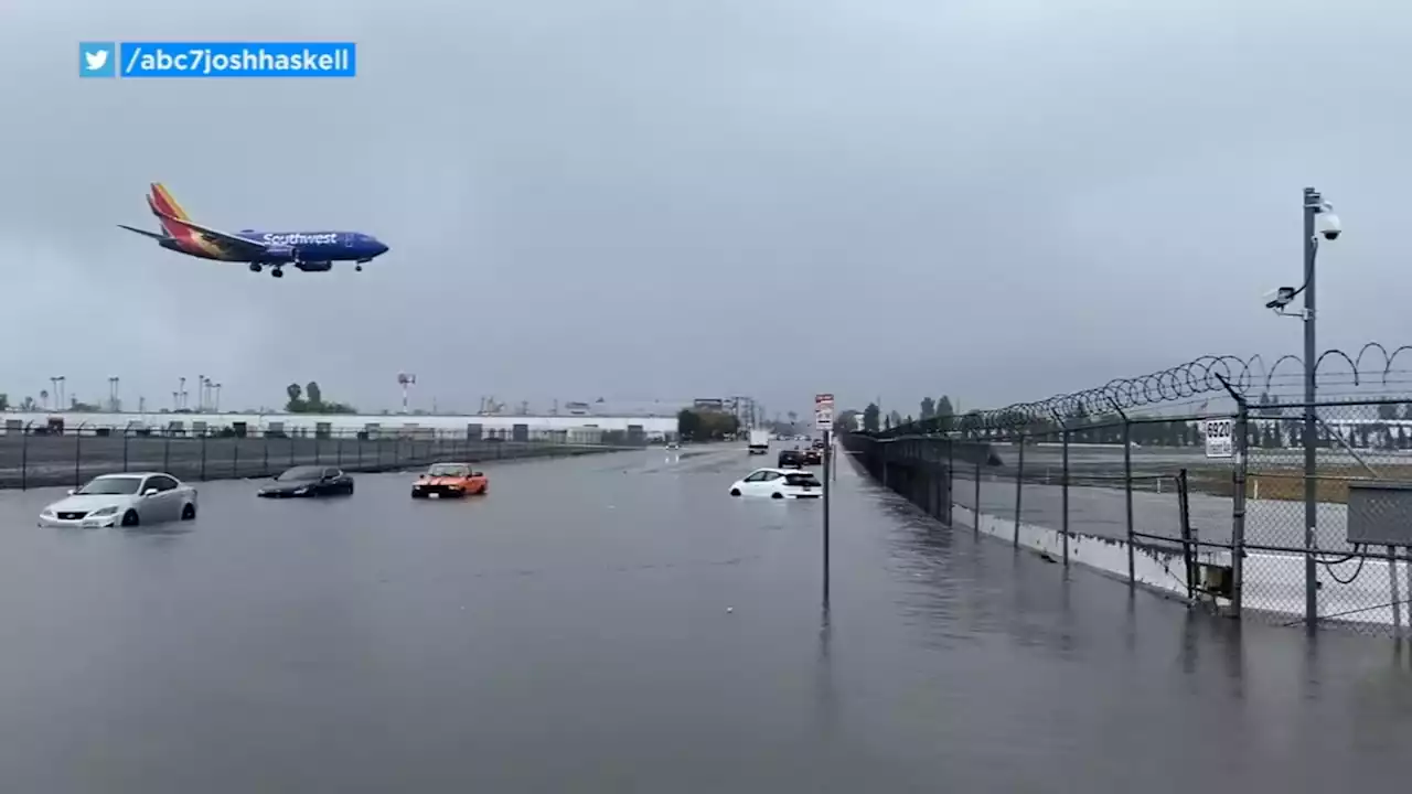 Cars stranded in flooded intersection near Hollywood Burbank airport as inbound planes fly overhead