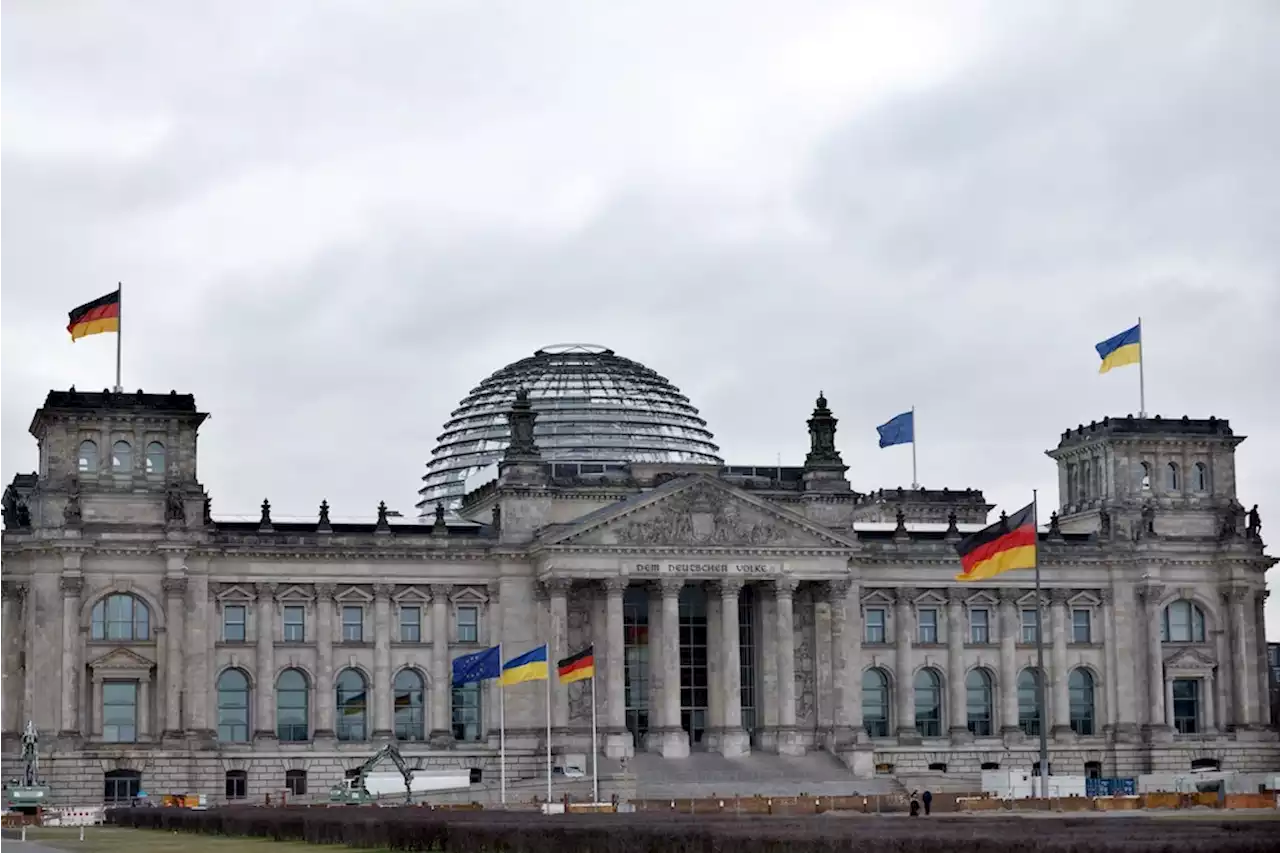 Letzte Generation kleistert Plakat an den Bundestag