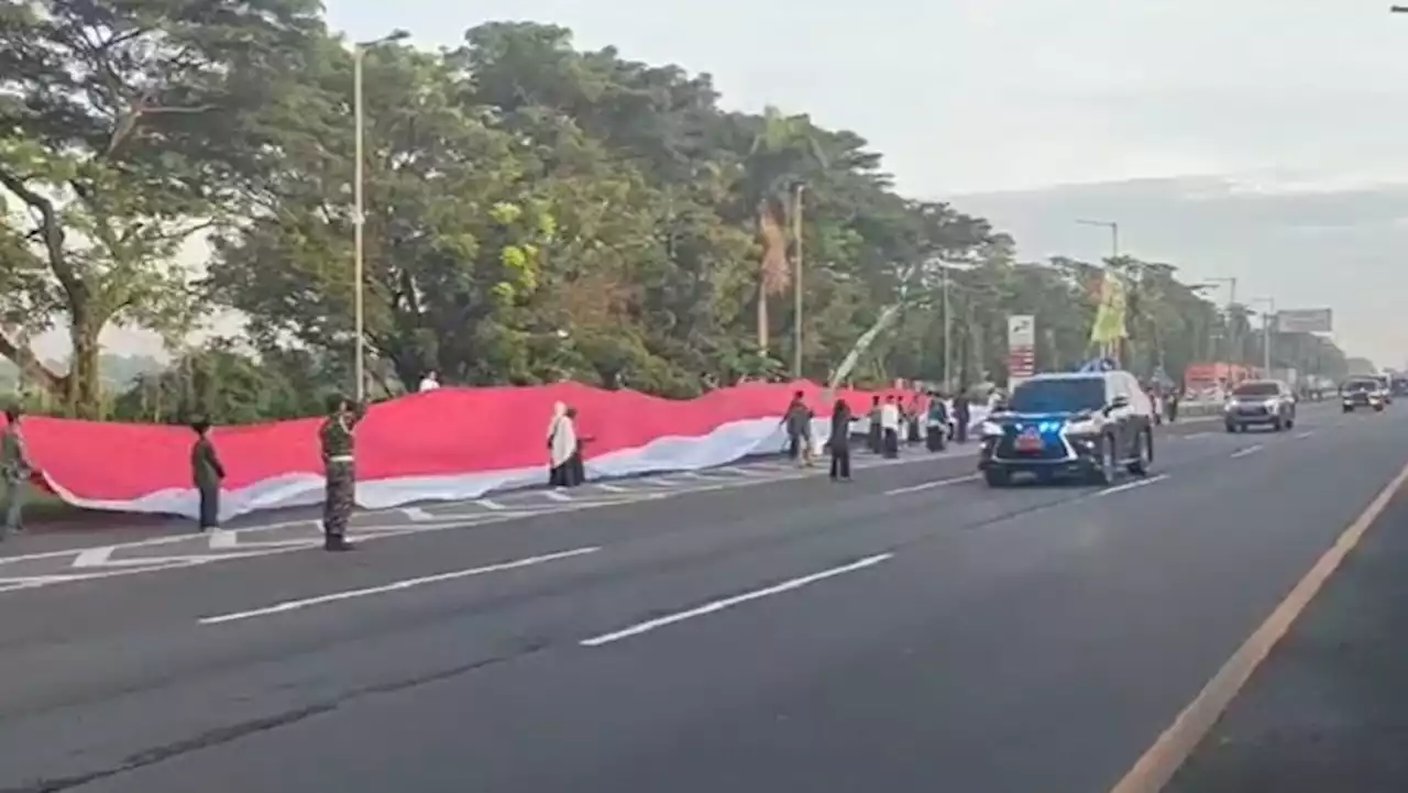 Sambut Rombongan Presiden, Jamaah 1 Abad NU Bentangkan Merah Putih Panjang di Rest Area Tol