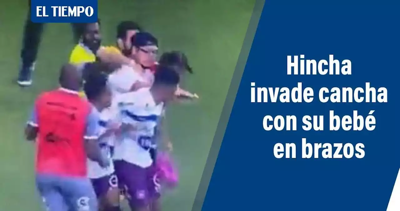 Hincha con bebé en brazos invade la cancha y agrede a futbolista, video