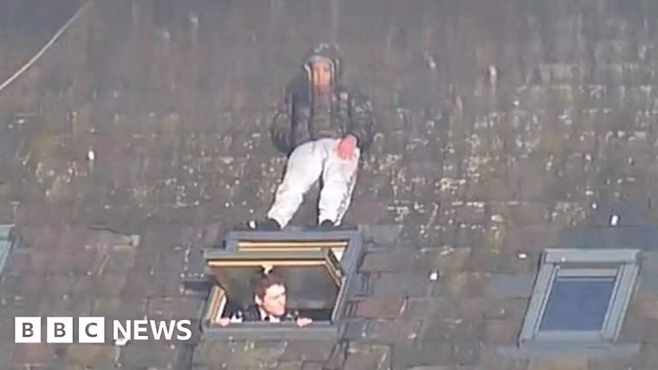 He's behind you - man hides from police on roof