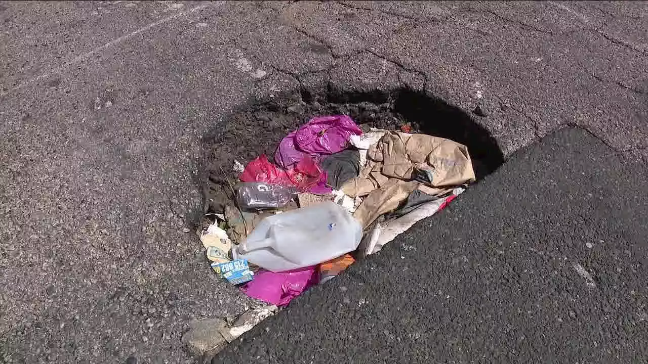 Trash-filled pothole in South Philadelphia creates danger for drivers, pedestrians