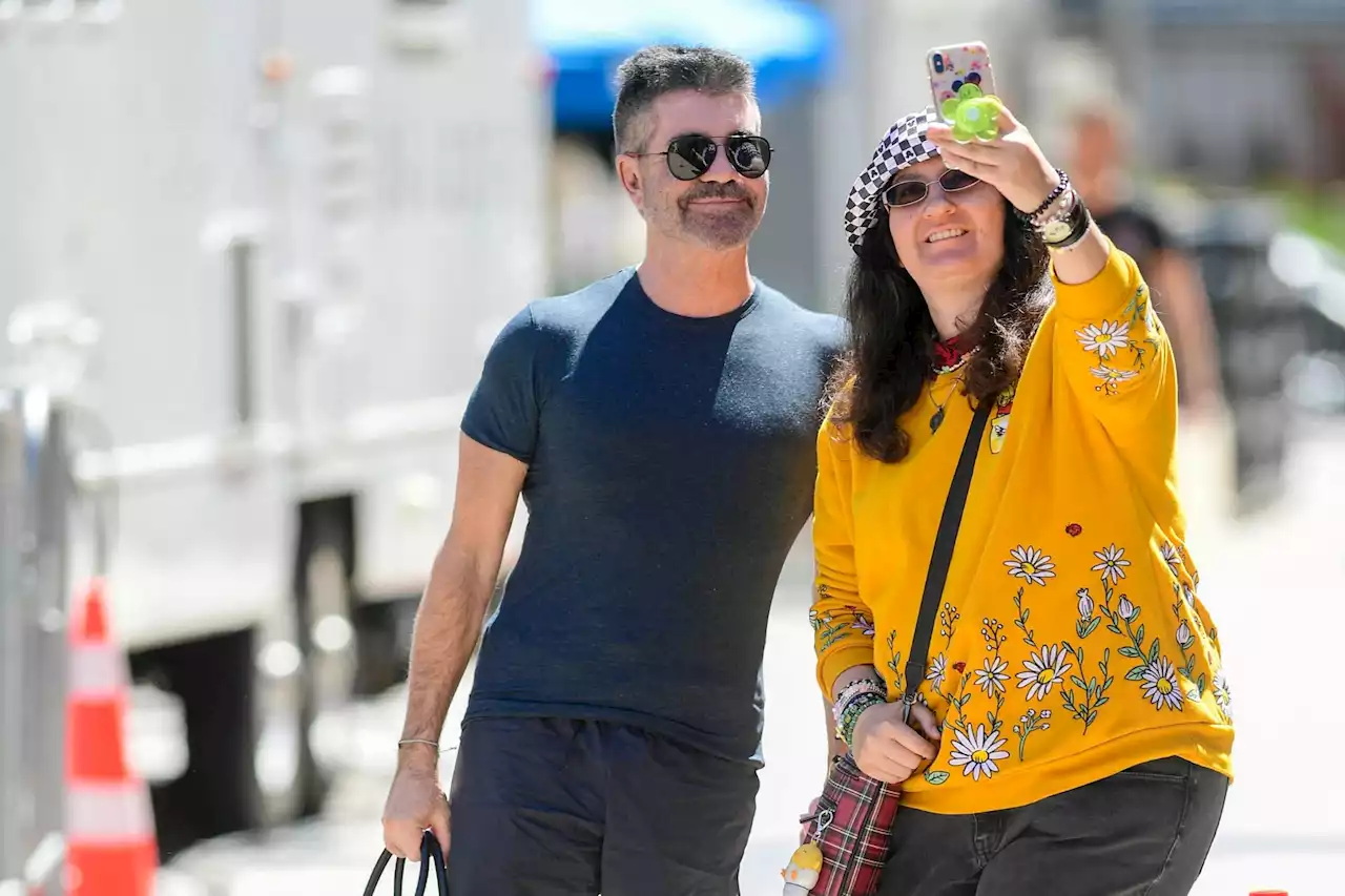 Simon Cowell looks slimmer than ever in all black as he poses with fan