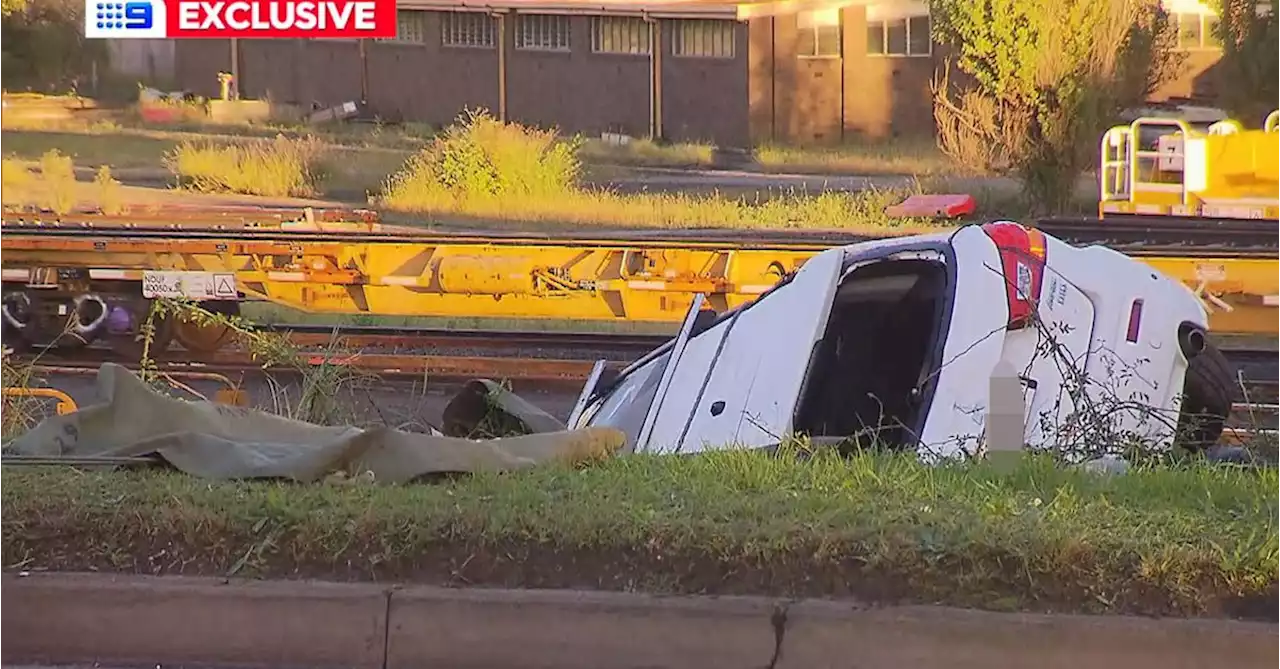 Car rolls down embankment, gets wedged under train line after crash in Sydney