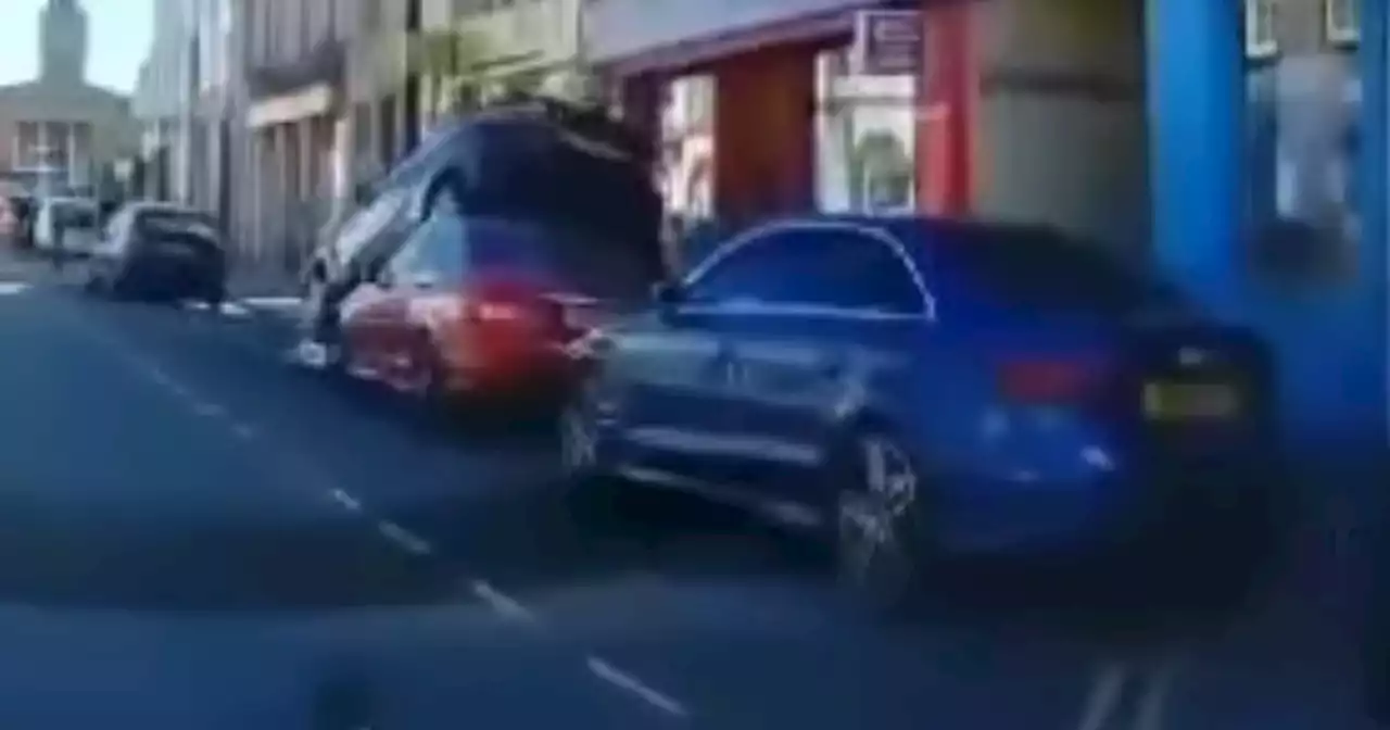 Shocking moment motorist reverses onto roof of parked car in Scots town