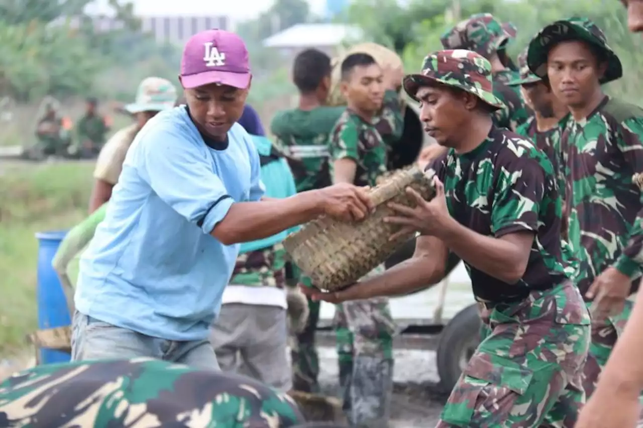 Perbaiki Jalan Rusak, Warga Desa Gulang dan Prajurit TNI Gotong Royong Angkut Pasir