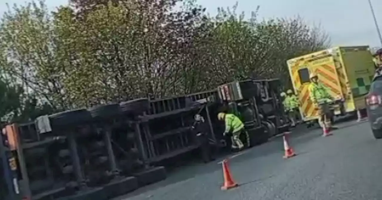 Live as emergency services attend overturned lorry on motorway roundabout