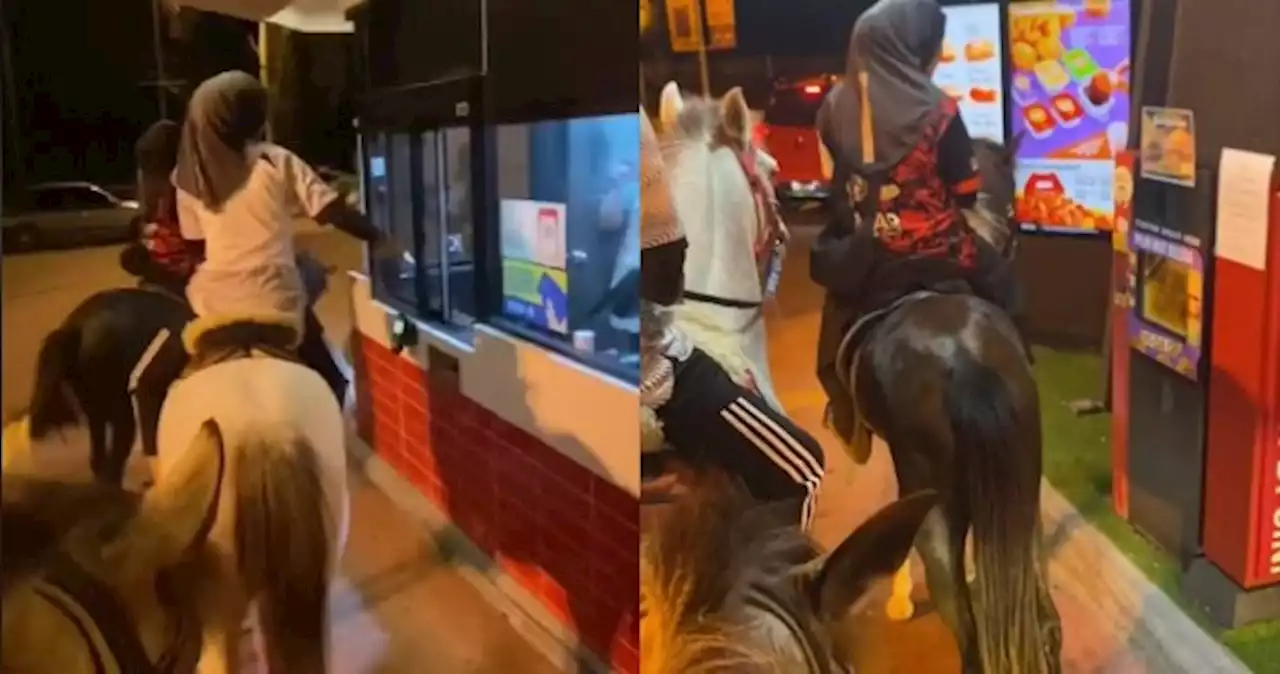 Horsing around: Malaysian teens trot over to McDonald's drive-through on horses, wait patiently behind car