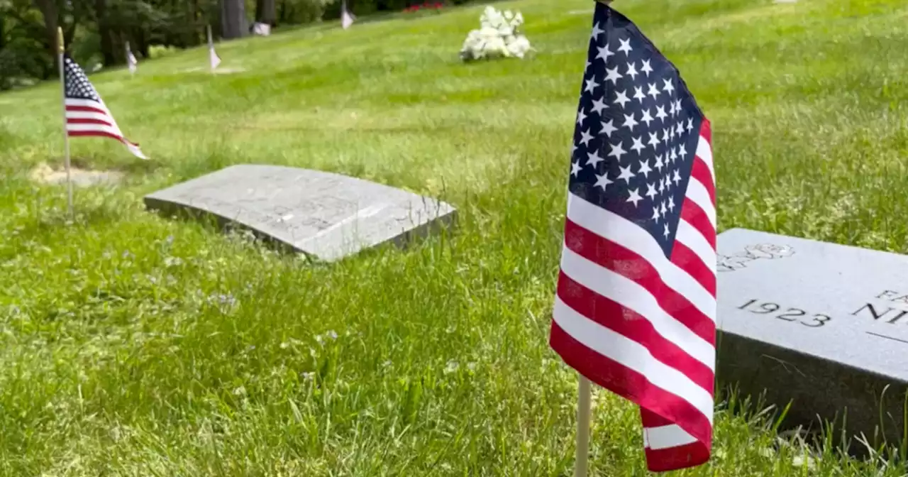 Volunteers begin the process of placing close to 9,000 flags on graves of veterans at Lake View Cemetery