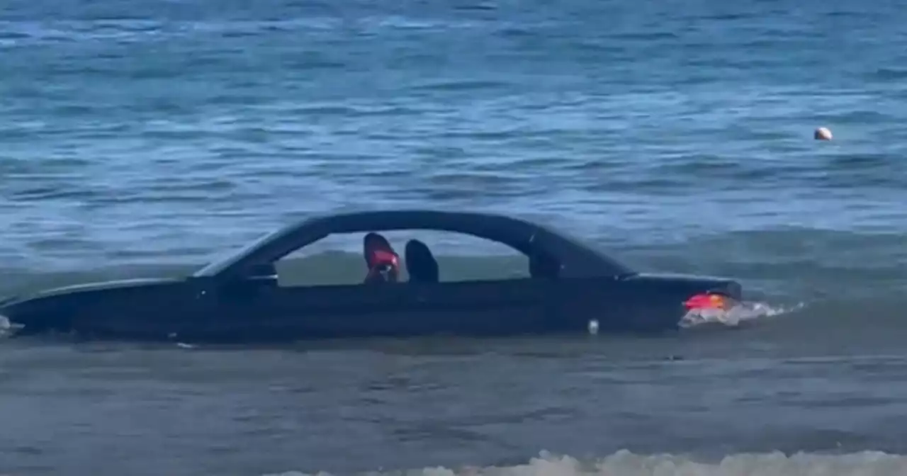 BMW convertible drifts out to sea after driver parked car on the beach