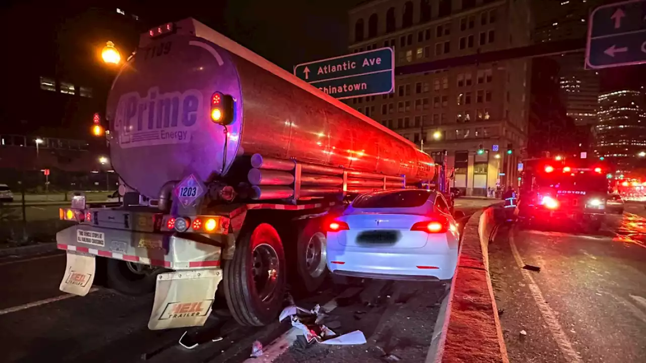 Driver rescued after Tesla is wedged between tractor-trailer, jersey barrier in Boston