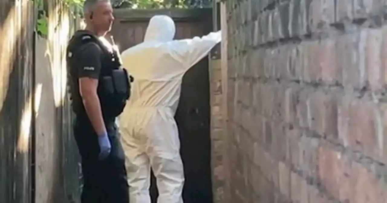 Police and forensics search back of raided home after three killed