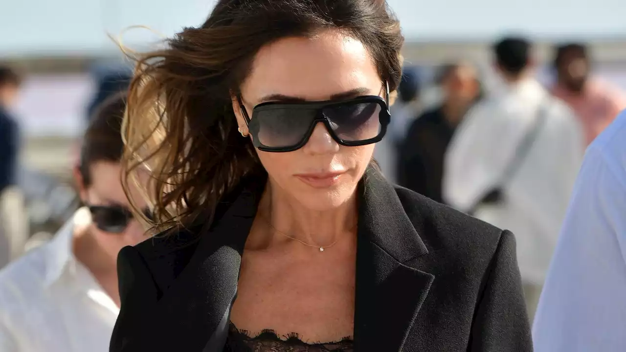 Victoria Beckham eleva su minivestido negro y con unas elegantes medias transparentes