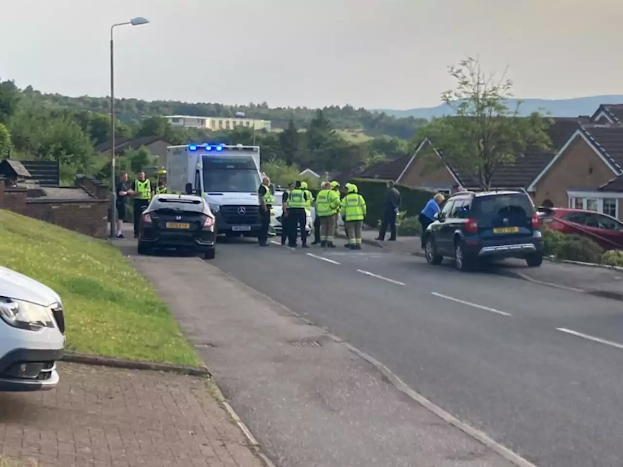 Woman taken to hospital and road closed after car crash