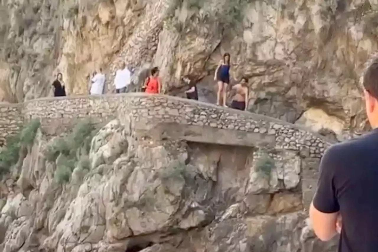 Woman hesitating to jump off Italian cliff slips, collides with rocks: video