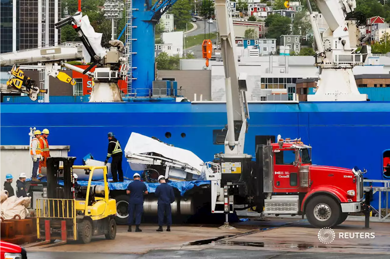 Presumed human remains and shattered Titanic submersible returned to shore