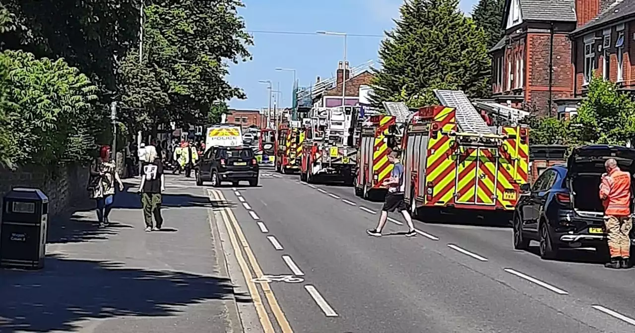 Busy Greater Manchester road brought to standstill after man climbs onto roof