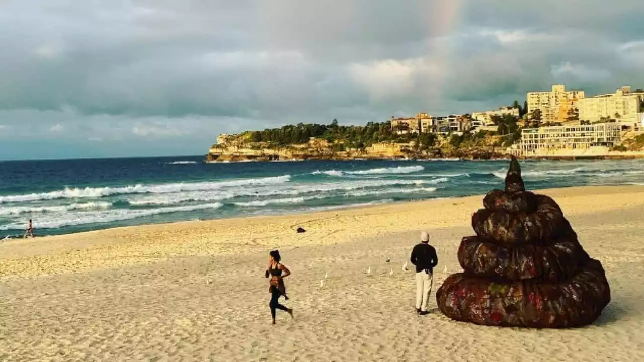 Here's why a four-metre poo sculpture was dropped on Australia's most popular beach