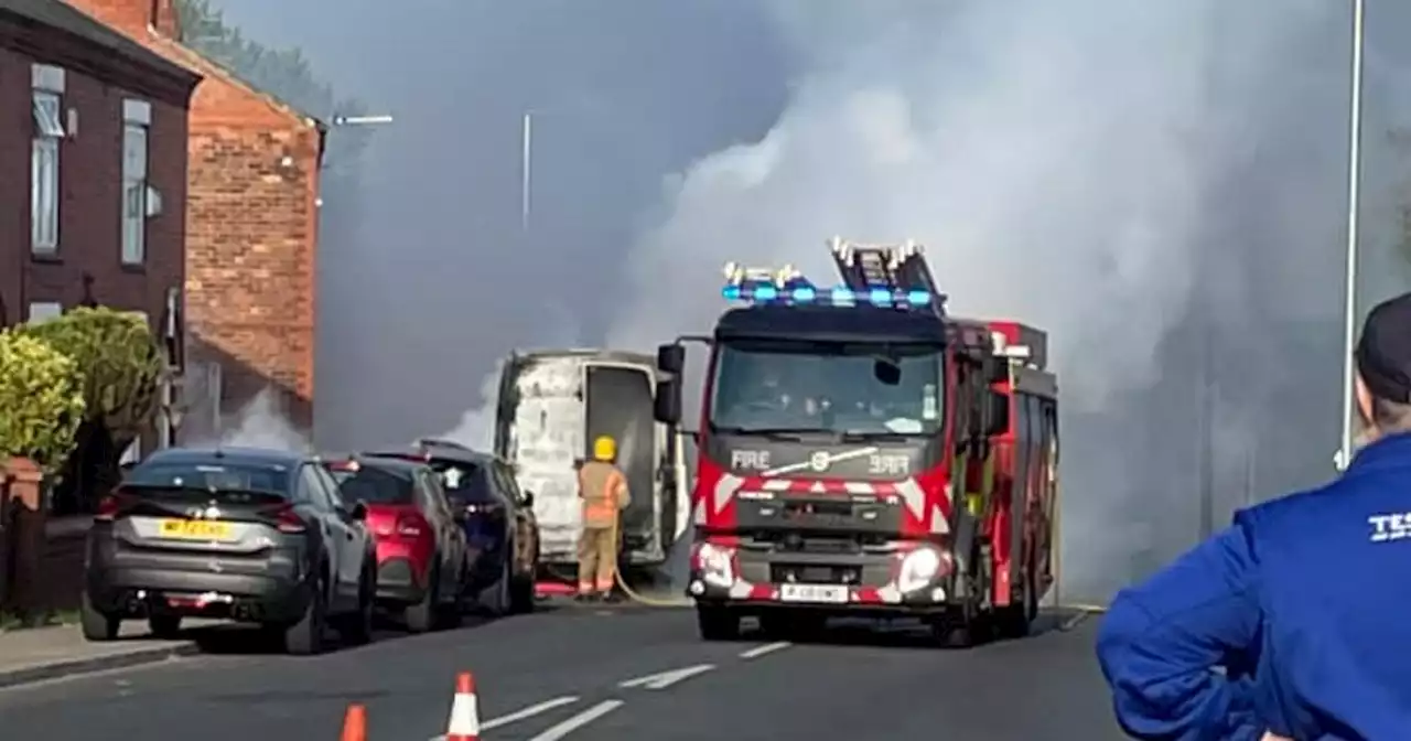 Huge plumes of black smoke seen with main road shut after van