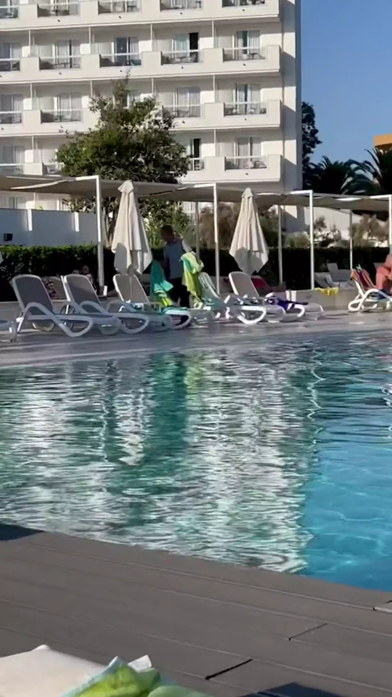 Moment hotel staff gets revenge on sunbed hoggers as worker snatches towels