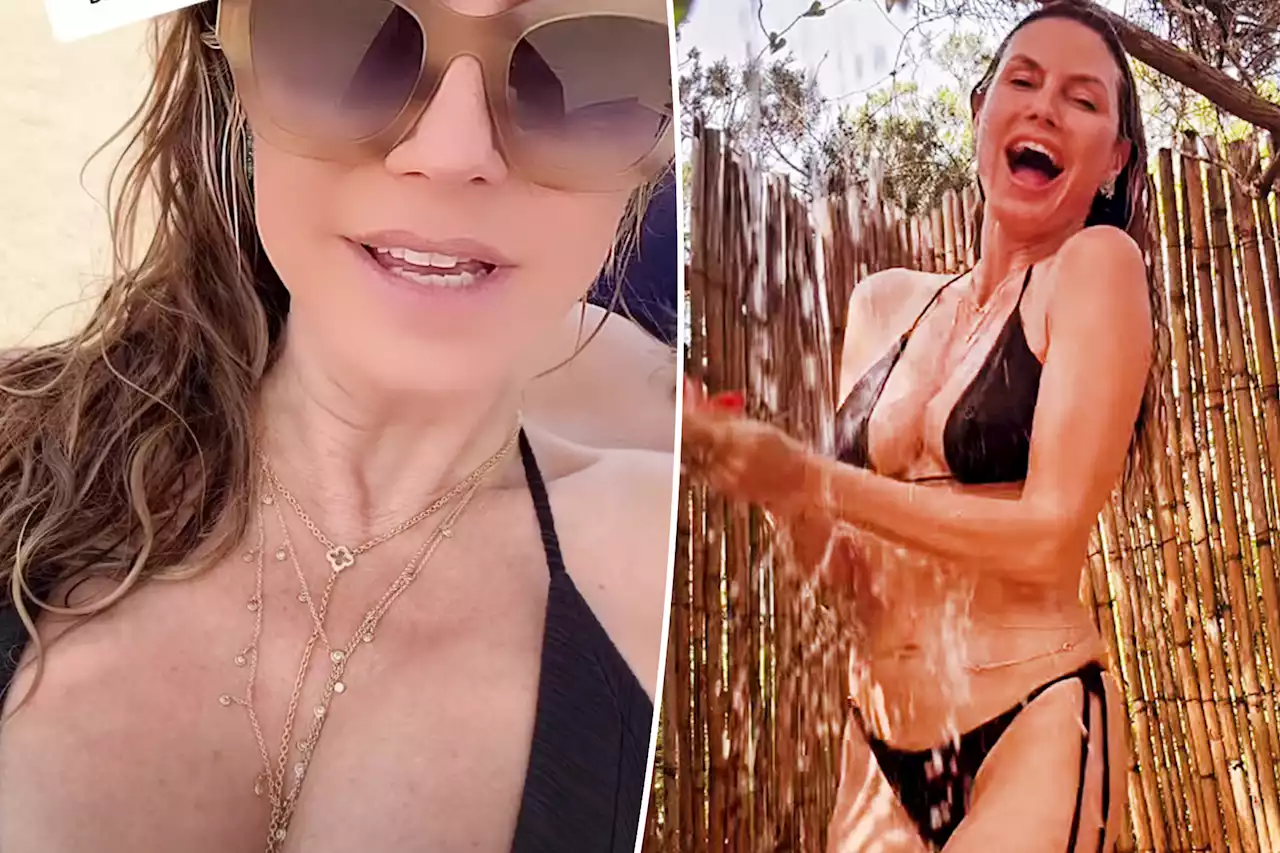 Heidi Klum takes a cold shower in black bikini and diamond body jewelry