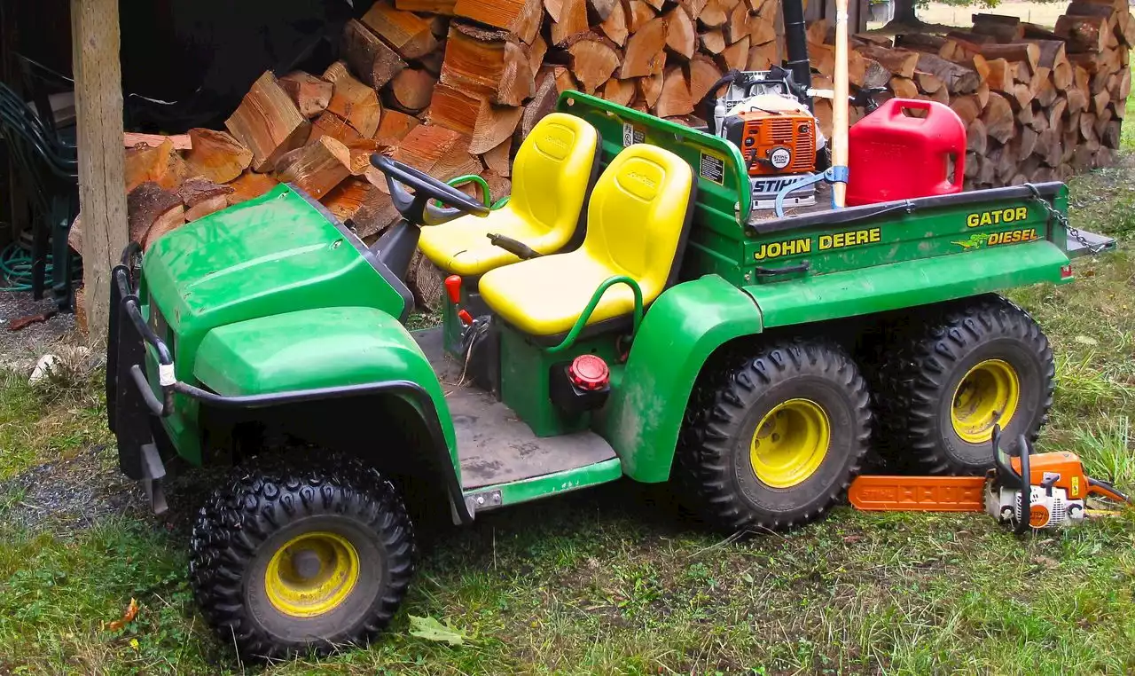 Mobile police arrest man in hospital gown, riding a John Deere