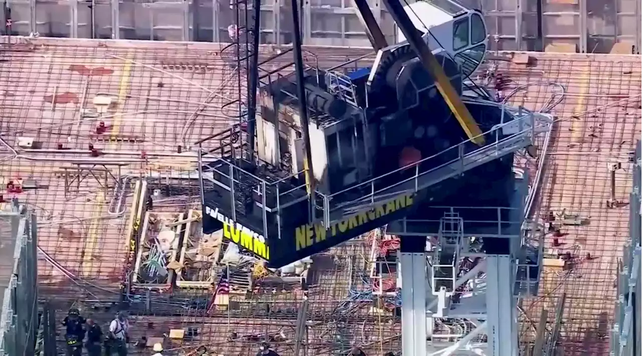 Construction crane catches fire in New York City and hits building as it crashes to street