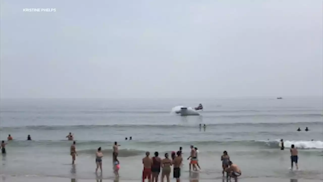 Small plane towing banner lands in the ocean off a crowded New Hampshire beach; pilot unhurt