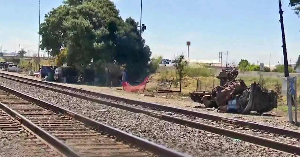 Oakland residents living near rail line beset by trash dumping, vehicle fires