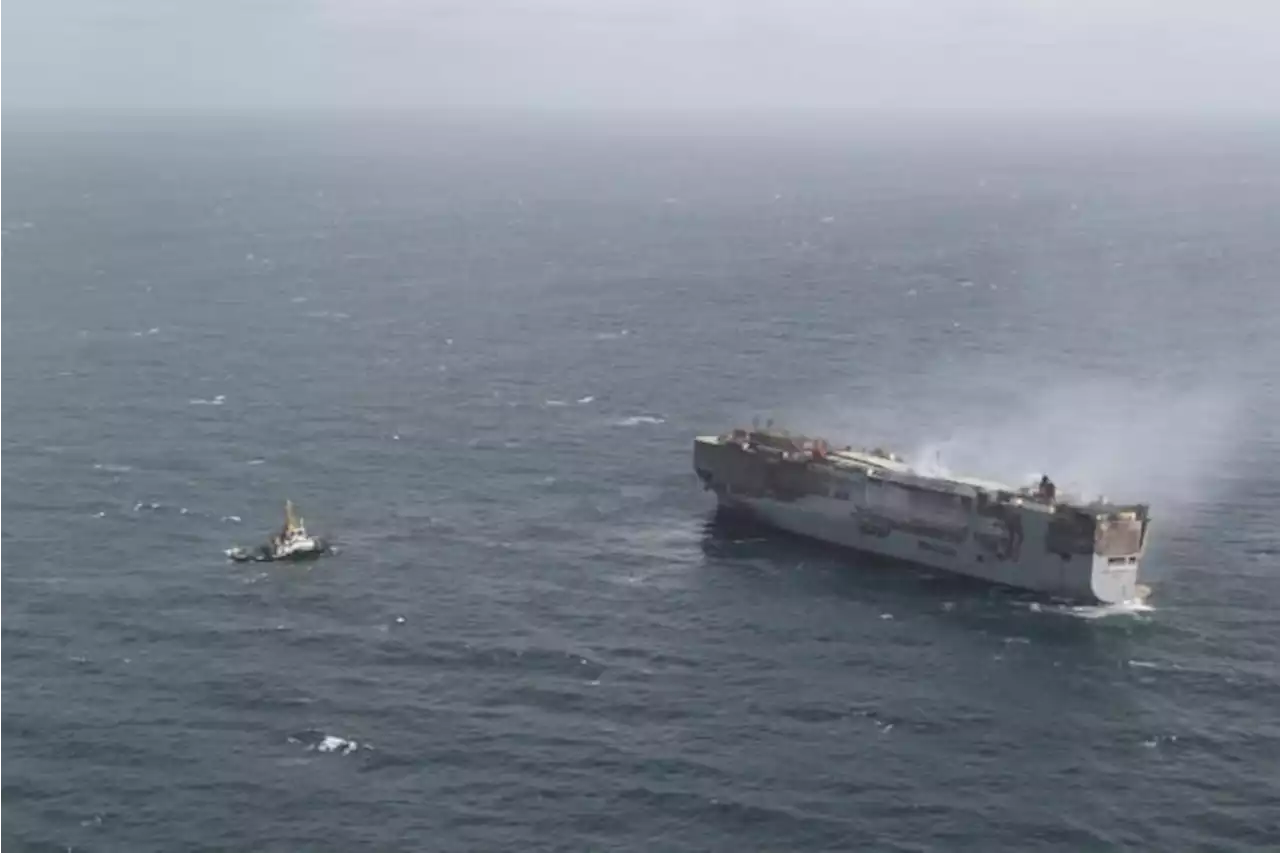 Salvage crews begin towing a burning cargo ship to a new location off the Dutch coast as smoke eases