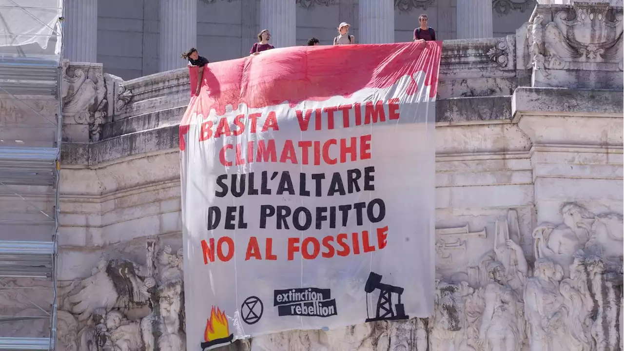 Attivisti per l'ambiente si incatenano all'Altare della Patria con uno striscione: “Basta vittime climatiche”