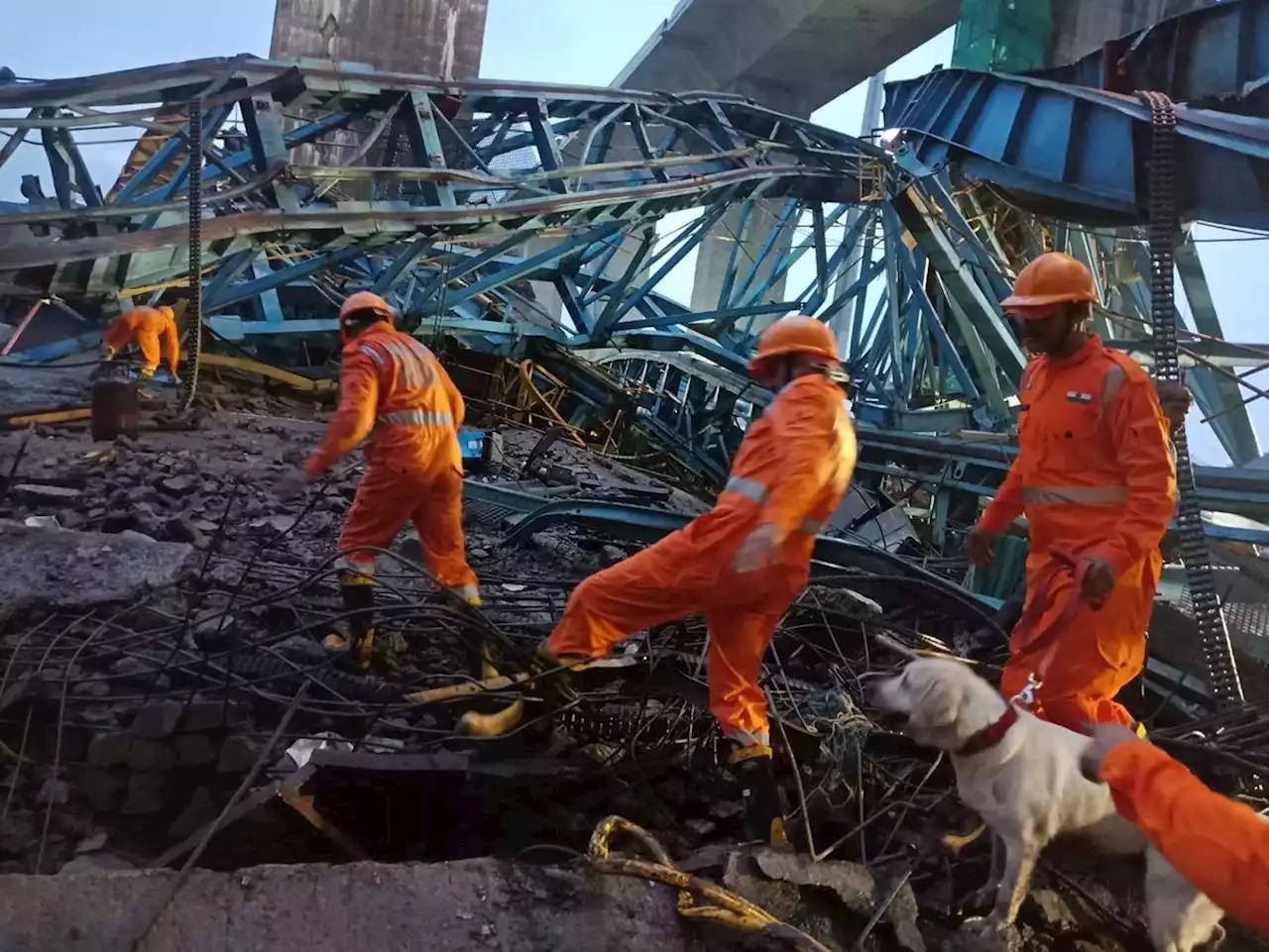 At least 14 workers killed in the collapse of a crane being used to build a bridge in India