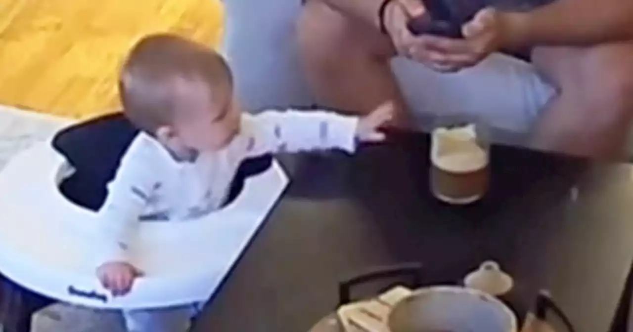 Watch viral video of baby stealing dad's coffee while he's distracted by his phone