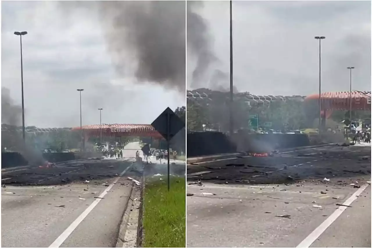 Plane crashes into Malaysia road, killing 2; vehicle parts strewn across the ground