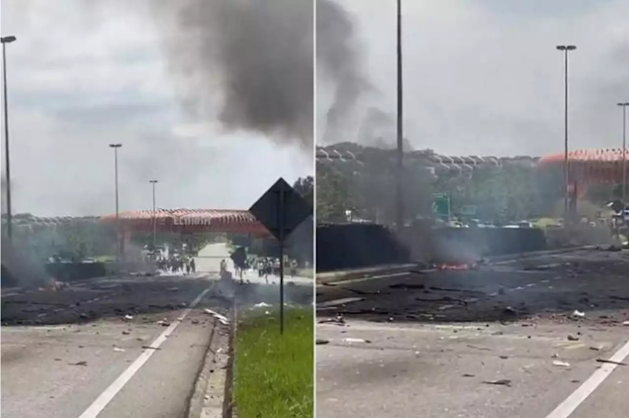 Plane crashes into Malaysia road, killing 2; vehicle parts strewn across the ground