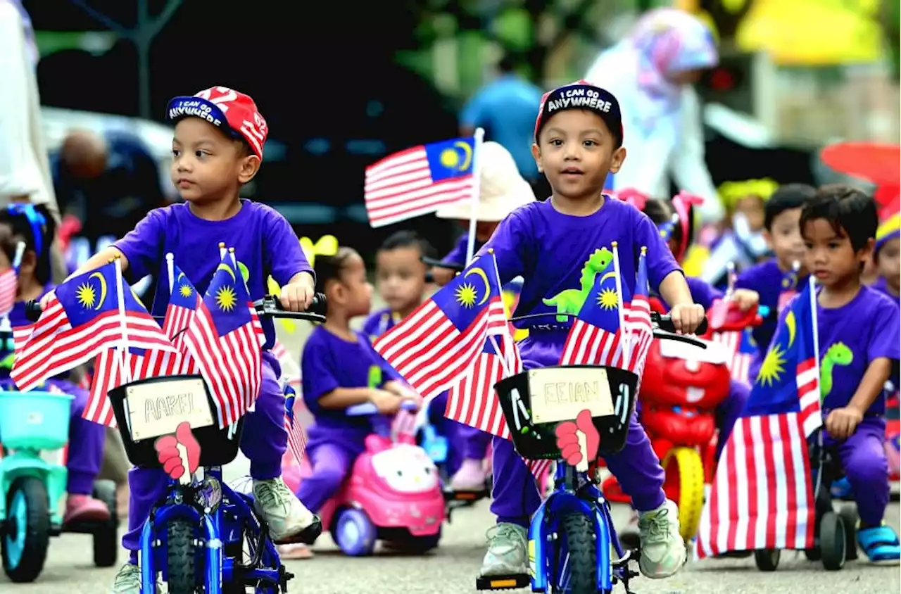 Kanak-kanak teruja berbasikal kibar Jalur Gemilang